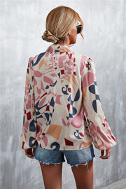 Women's abstract print blouse with balloon sleeves and a pussy bow neckline, in a multi-color pattern.
