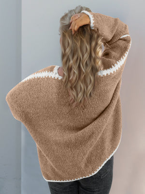 Oversized knit cardigan in tan with white contrast stitching on the neckline, sleeves, and hem.