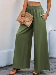 Textured elastic waist palazzo trousers in moss green with wide legs and pockets.