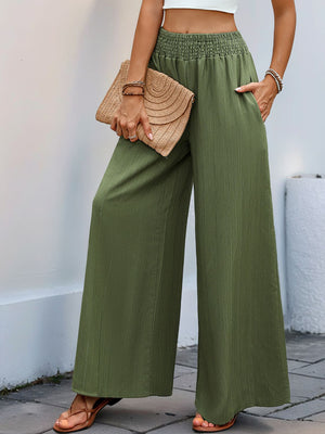 Textured elastic waist palazzo trousers in moss green with wide legs and pockets.