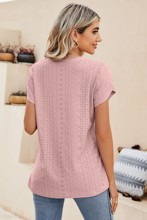 Blush pink knit top with allover eyelet detail and short sleeves.