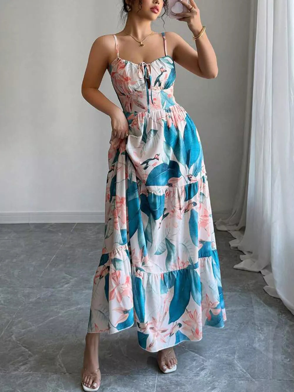 Maxi dress with spaghetti straps, sweetheart neckline, and tiered skirt in a tropical floral print.