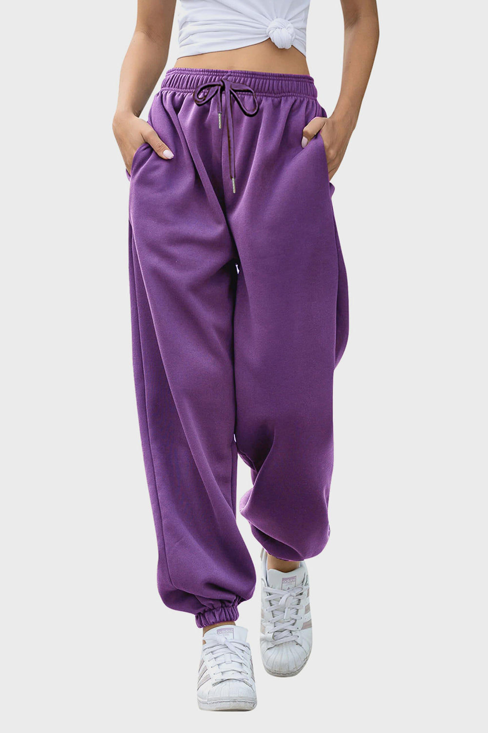 Purple slouchy sweatpants with gathered cuffs and drawstring waist.