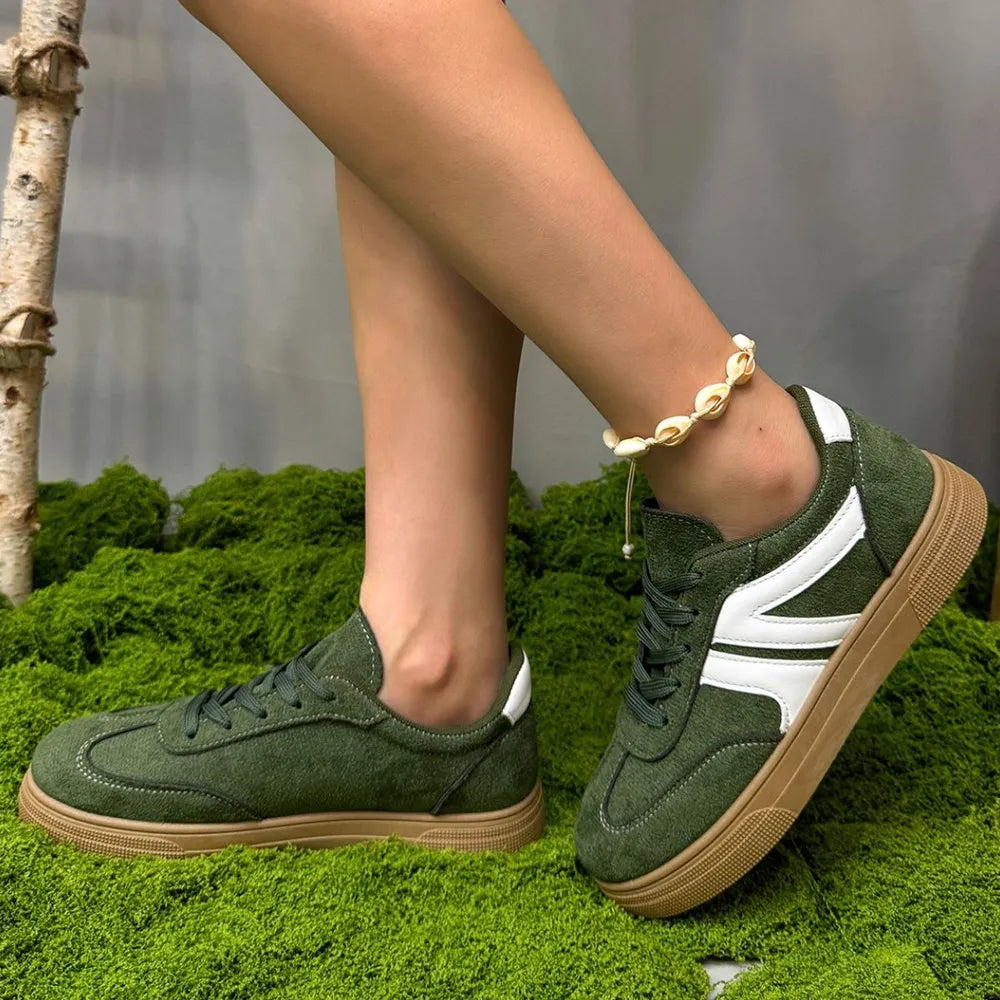 Green suede panel sneakers with white accents and gum soles.