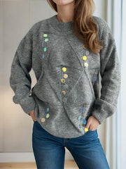 Gray knit sweater with geometric sequin embellishments and crew neck.