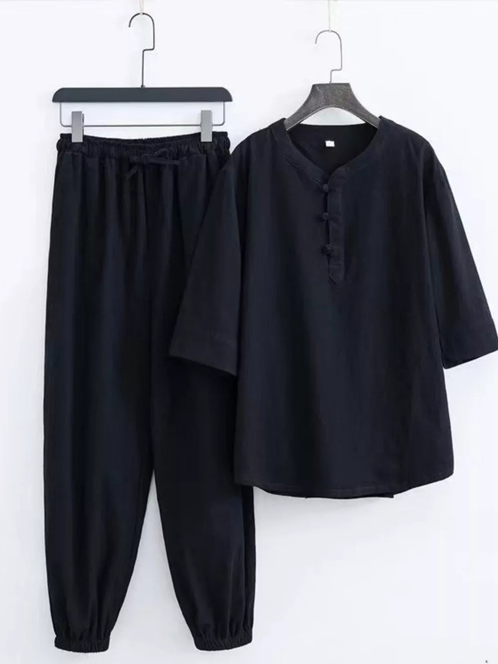 Black Chinese-inspired men's relaxed fit pants set with drawstring waist and button-up top.