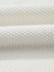 White chenille chunky knit sweater with crew neck, showing fabric texture.