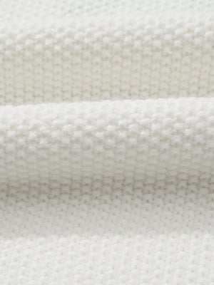 White chenille chunky knit sweater with crew neck, showing fabric texture.