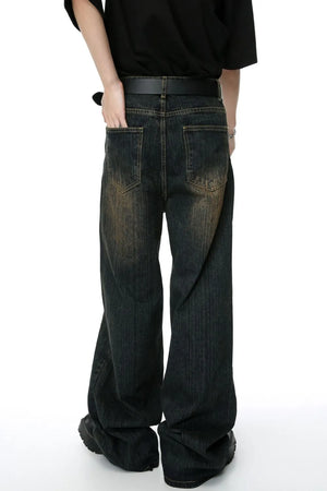 Dark wash wide-leg denim jeans with a distressed, faded look and vertical texture.