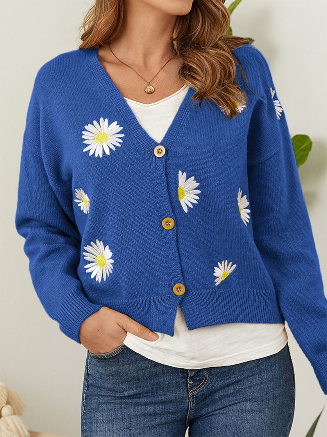 Royal blue V-neck cardigan with white daisy embroidery and button front.