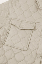 Quilted utility jacket in camel with snap-button chest pocket detail.