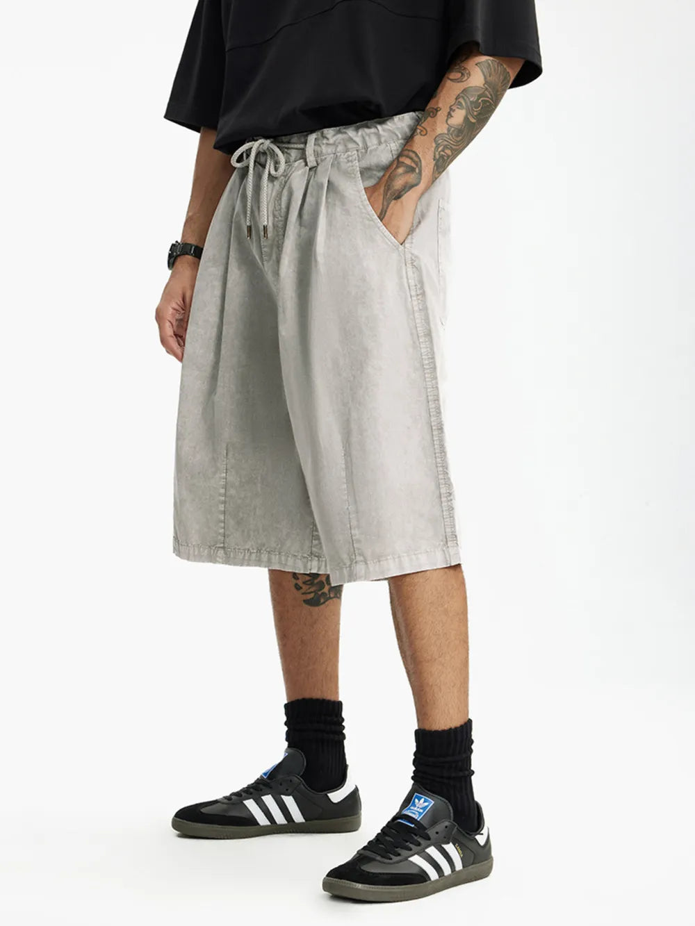 Men's light gray cotton wide-leg chino shorts with drawstring waist and pockets.