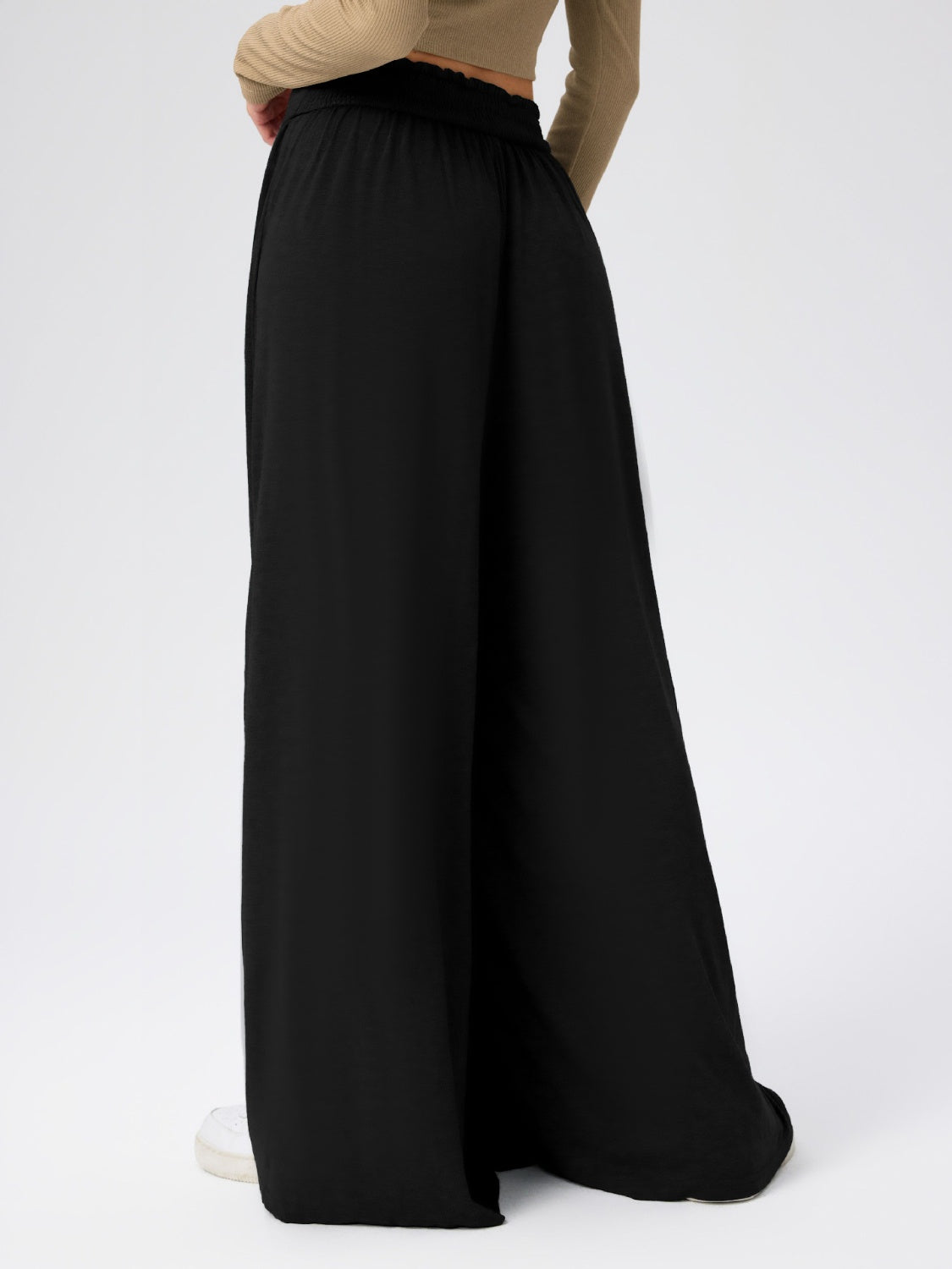 Black jersey wide-leg trousers with a drape-front detail and elastic waistband.