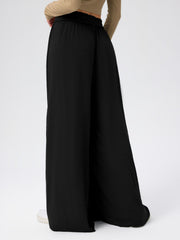 Black jersey wide-leg trousers with a drape-front detail and elastic waistband.