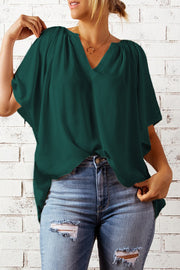 Relaxed green V-neck blouse with gathered neckline and cap sleeves.
