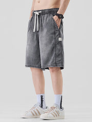 Men's dark gray loose fit denim shorts with drawstring waist and side pockets.