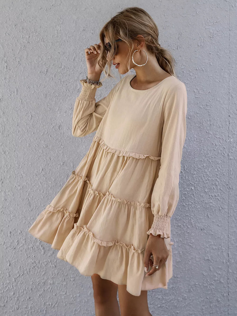 Apricot ruffled mini dress with long sleeves and tiered skirt.