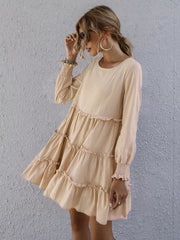 Apricot ruffled mini dress with long sleeves and tiered skirt.