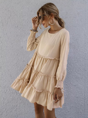 Apricot ruffled mini dress with long sleeves and tiered skirt.