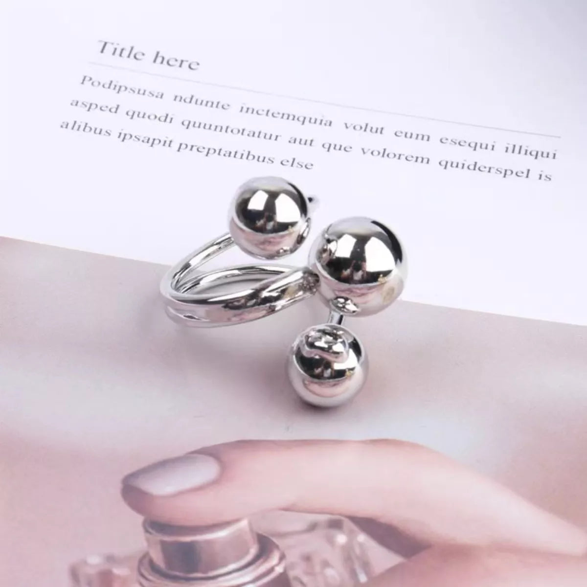 Silver multi-layered ball ring with a modern, abstract design.