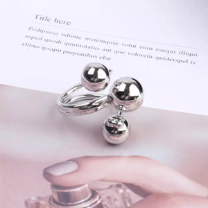 Silver multi-layered ball ring with a modern, abstract design.
