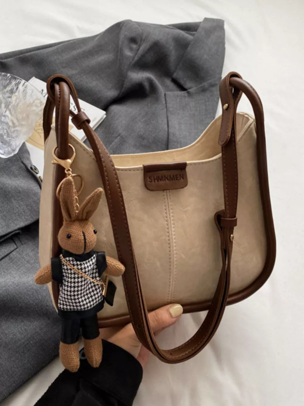 Off-white pu leather shoulder bag with brown piping and bunny charm