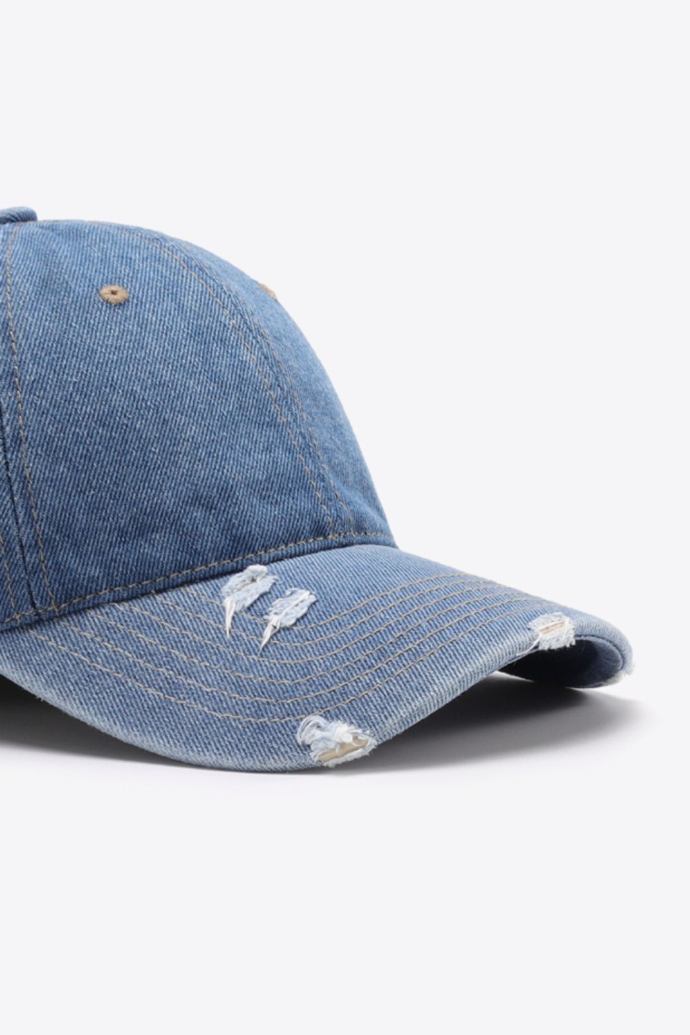Denim baseball cap in light blue with distressed details and adjustable strap.