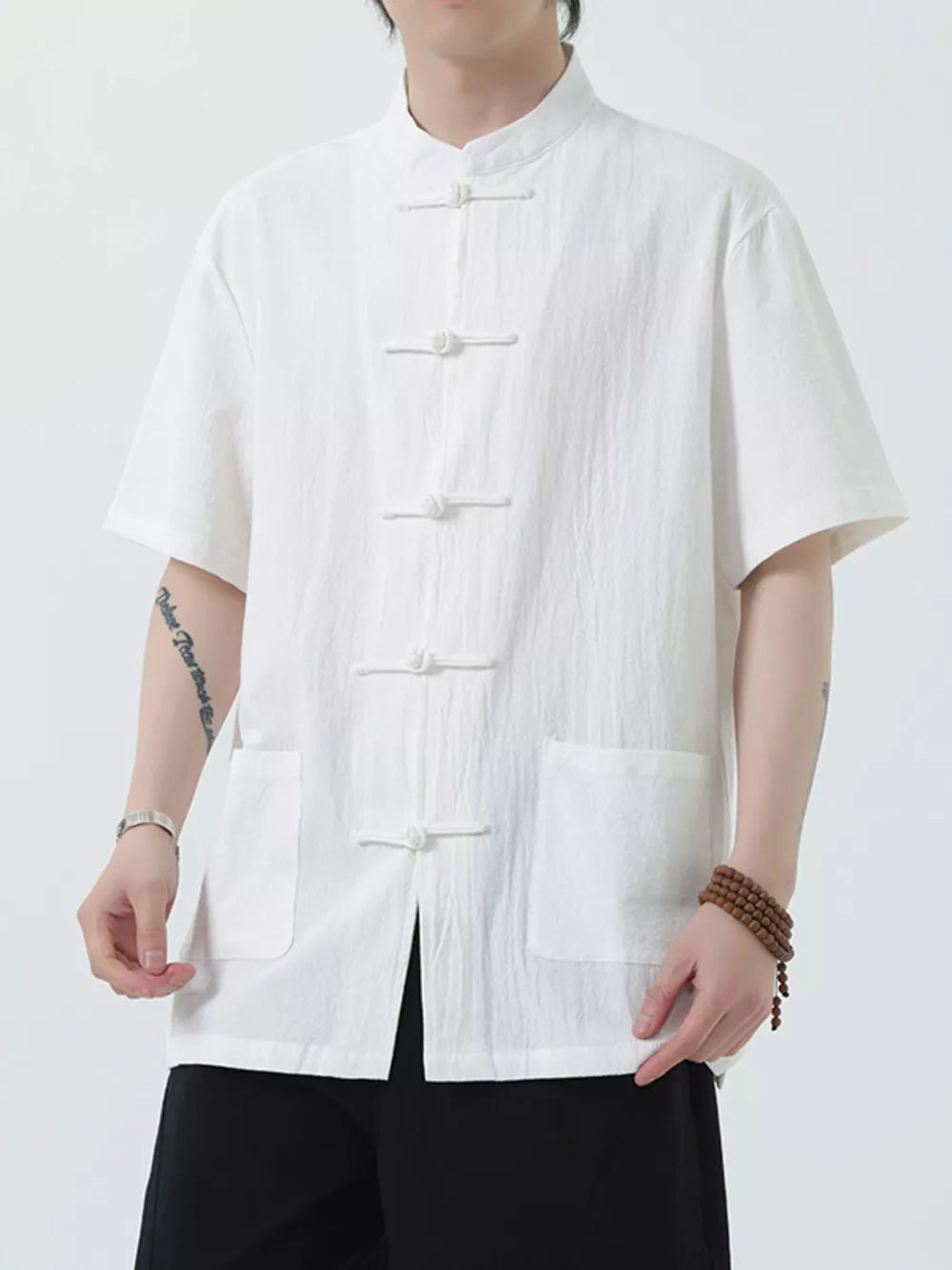 White cotton short-sleeve shirt with mandarin collar and frog button closure, two chest pockets.