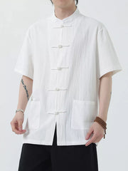 White cotton short-sleeve shirt with mandarin collar and frog button closure, two chest pockets.