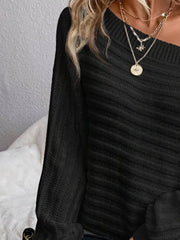 Black ribbed knit one-shoulder sweater with long sleeves.