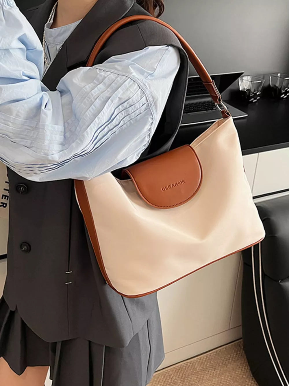 Chic canvas hobo crossbody bag in ivory with brown trim and flap.