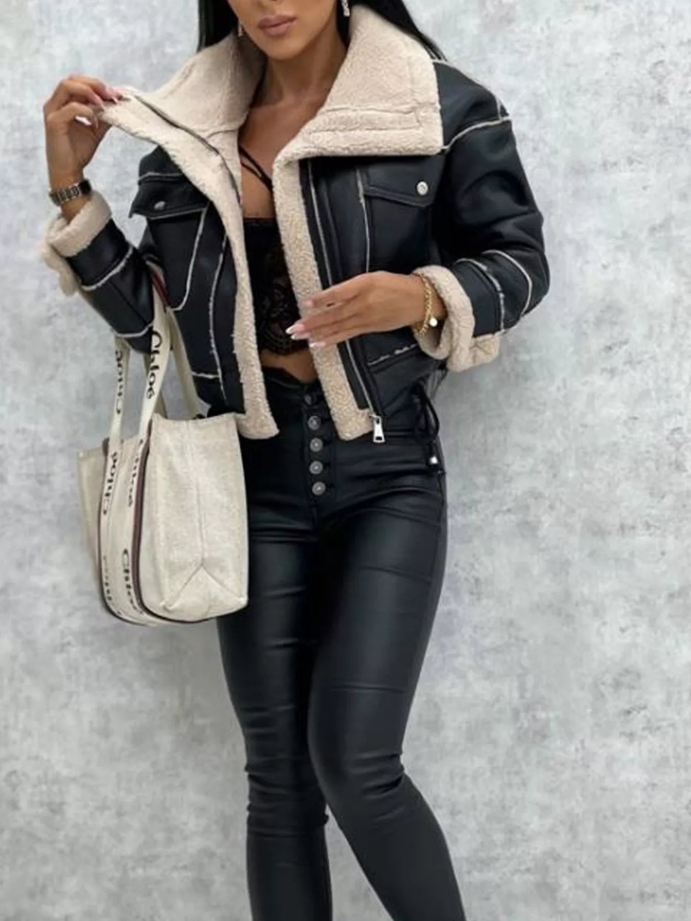 Black cropped sherpa-trim jacket with white stitching and shearling collar.