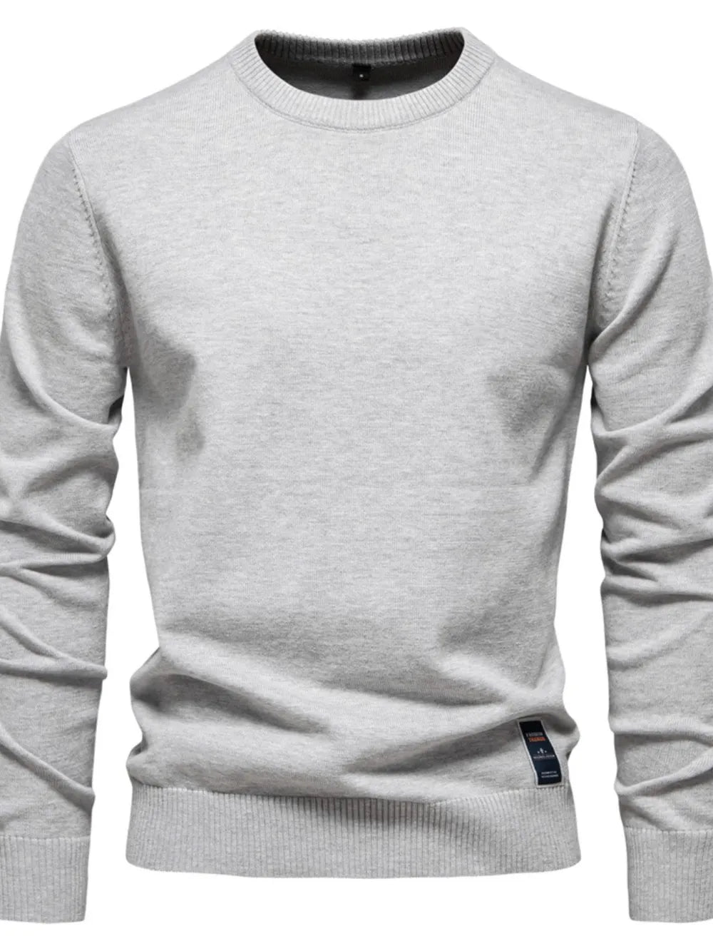 Gray crew neck knit sweater with ribbed cuffs and hem, featuring a small tag detail.