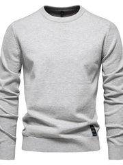 Gray crew neck knit sweater with ribbed cuffs and hem, featuring a small tag detail.