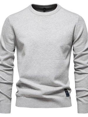 Gray crew neck knit sweater with ribbed cuffs and hem, featuring a small tag detail.