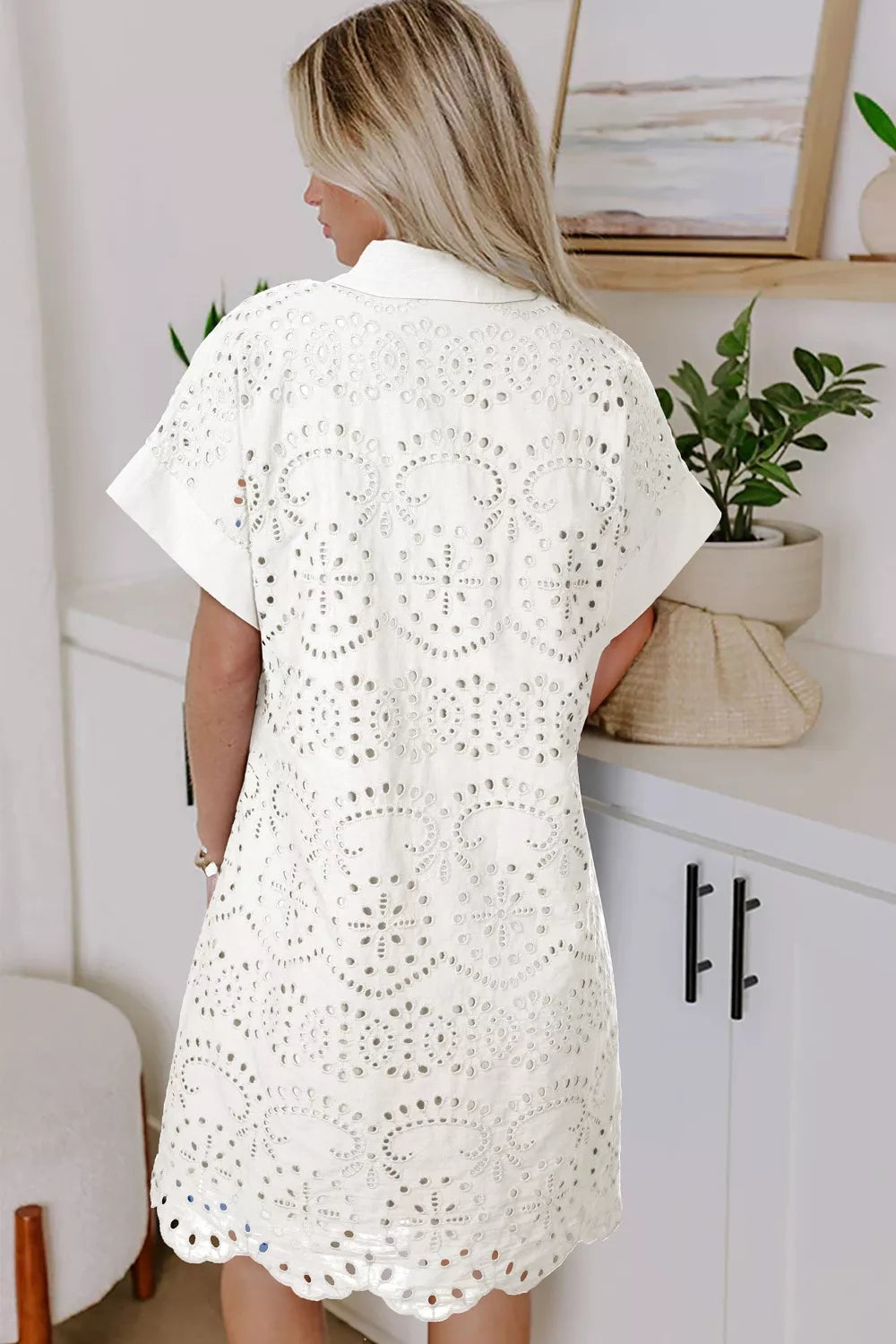 White eyelet embroidered mini dress with short sleeves and a collared neckline.