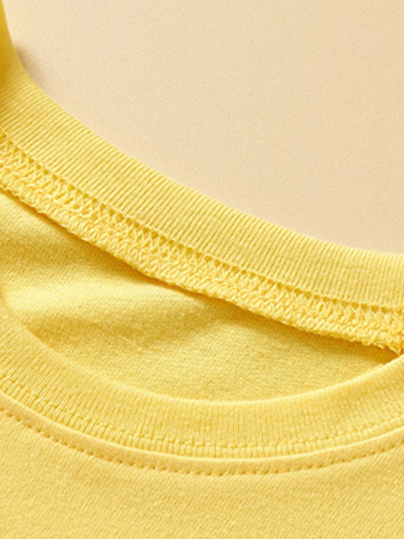 Yellow cotton toddler t-shirt neckline detail with double stitching.