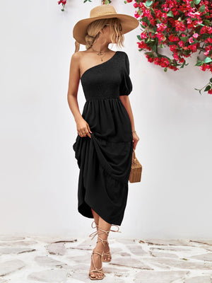Black smocked bodice tiered one-shoulder dress with puff sleeve and ruffle hem.