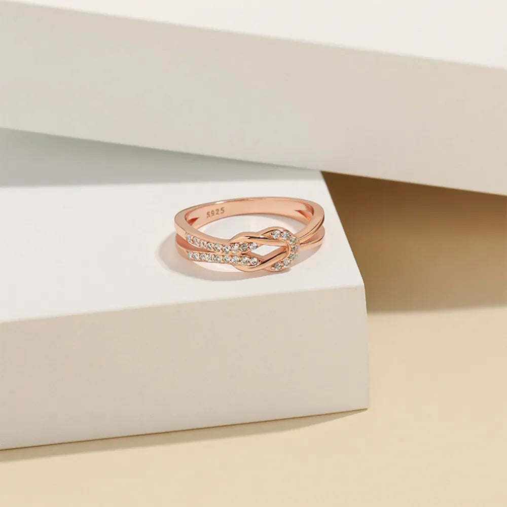 Rose gold knot ring with pave zirconia detail and double band.