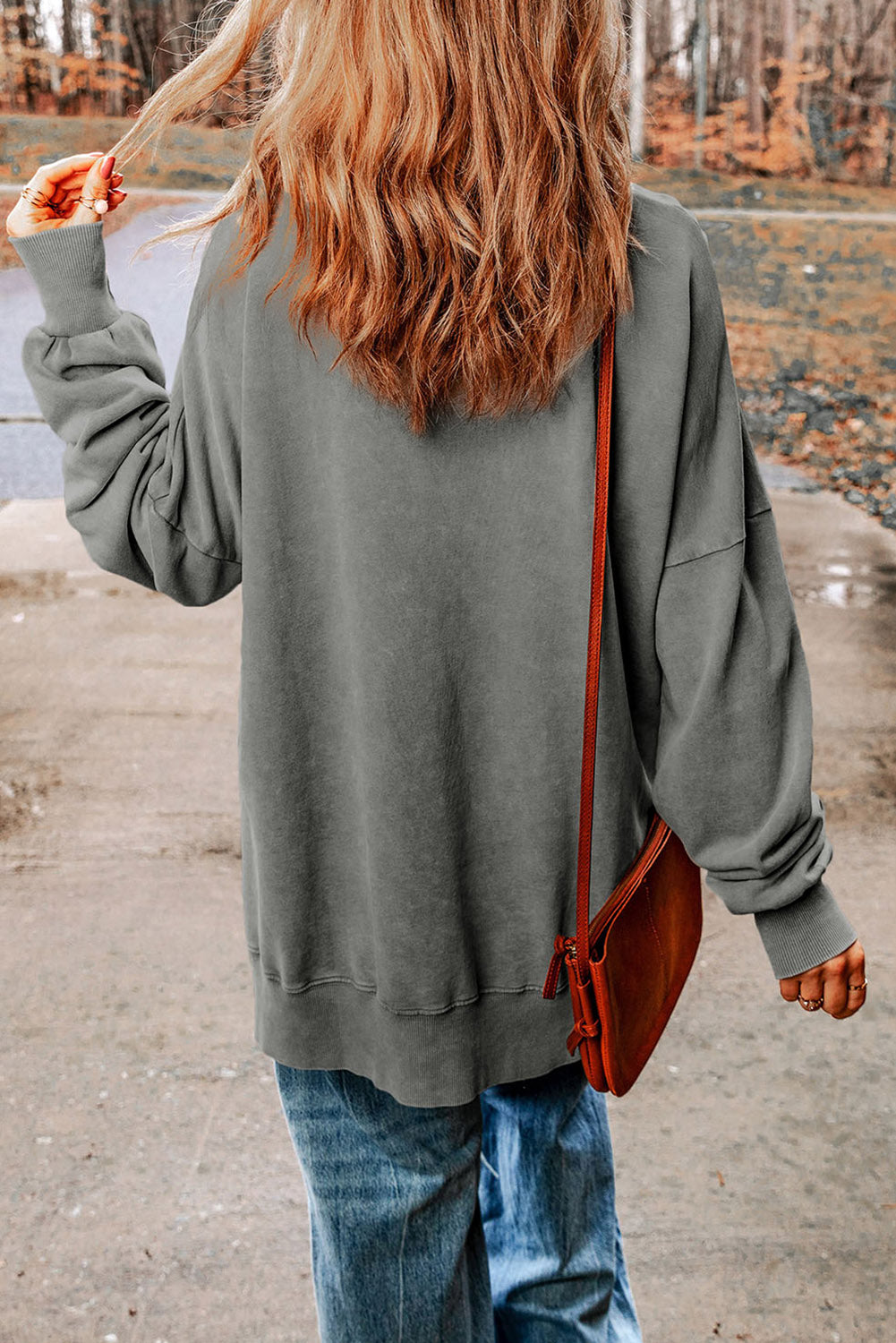 Dark gray casual sweatshirt with crew neck and long sleeves, styled with jeans.