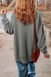Dark gray casual sweatshirt with crew neck and long sleeves, styled with jeans.