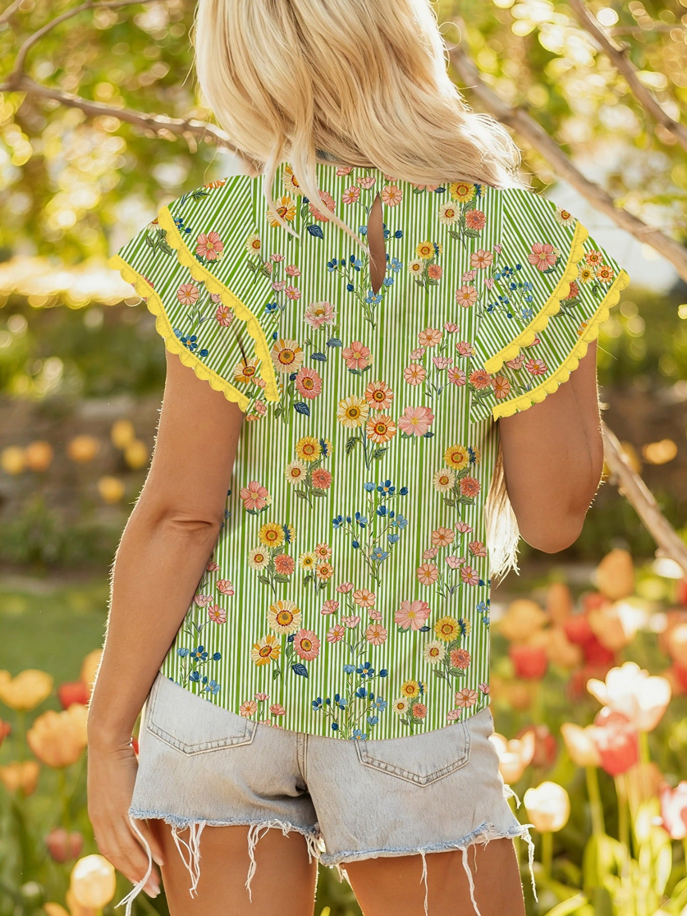 Floral printed cotton blouse with ruffle sleeves and yellow trim.