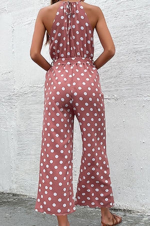 Red polka dot halter neck palazzo jumpsuit with tie back and belted waist.