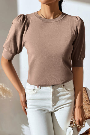 Camel knit sweater with puff sleeves and crewneck, styled with white jeans.