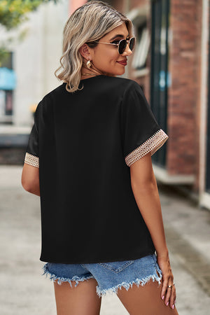 Black V-neck blouse with lace trim on short sleeves and neckline.