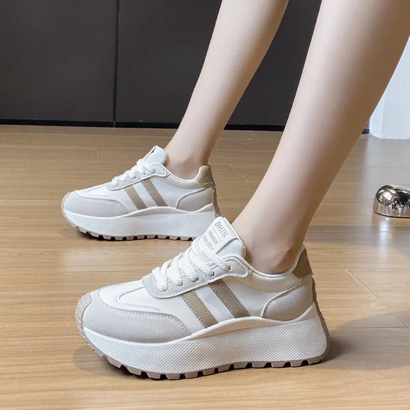 White platform trainers with beige retro stripes and lace-up closure.