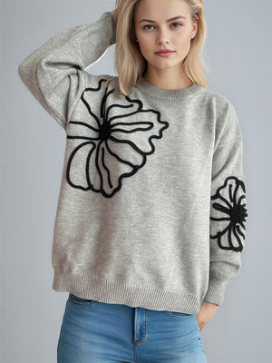 Gray knit sweater with black floral applique, crew neck, long sleeves.