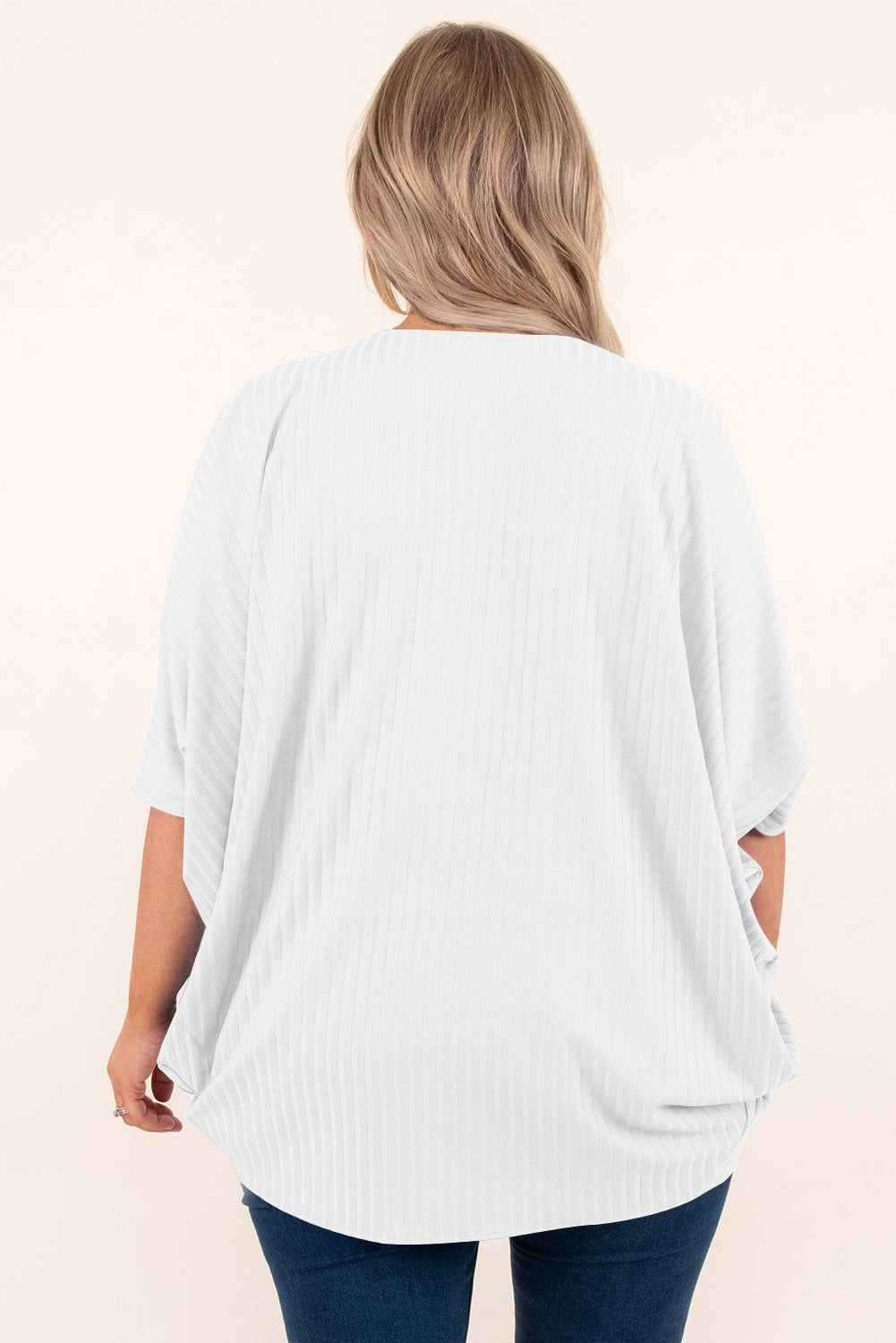 White ribbed batwing cardigan with short sleeves and a draped front.
