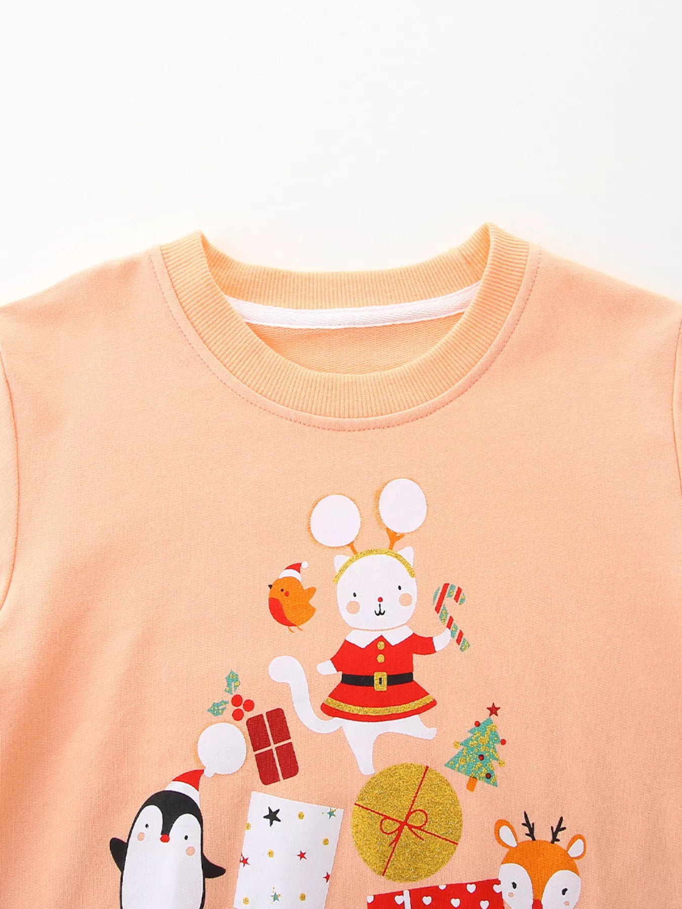 Children's crewneck sweatshirt in peach with festive Christmas cat, penguin, deer, and gift print.