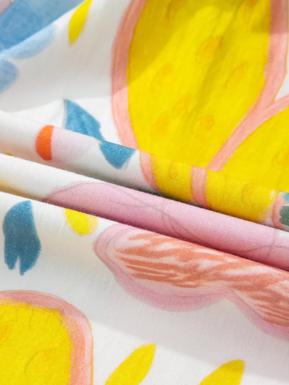 Midi dress in cotton with a whimsical floral doodle print in yellow, pink, blue, and orange.